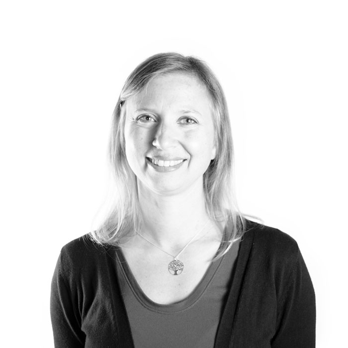 A marketing expert captures a black and white photo of a woman smiling.
