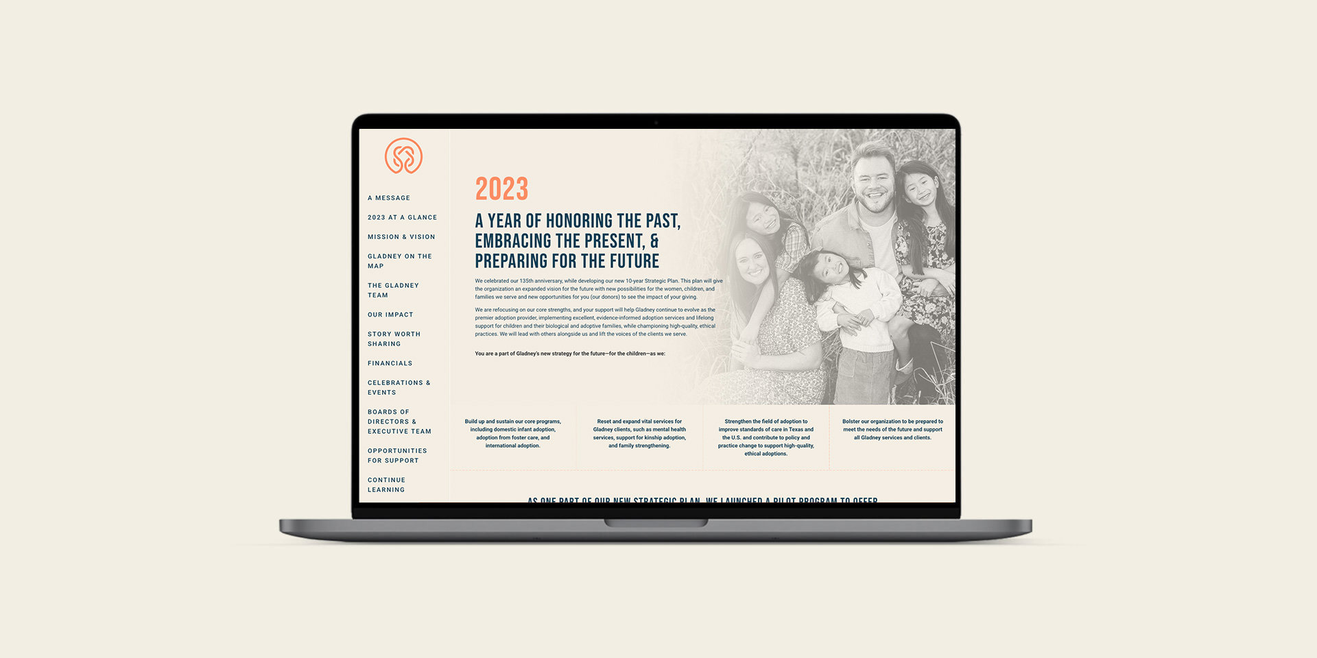 A laptop displaying a website featuring "2023: A Year of Honoring the Past, Embracing the Present, & Preparing for the Future" sits beside a beautifully crafted print design of a cherished family photo.
