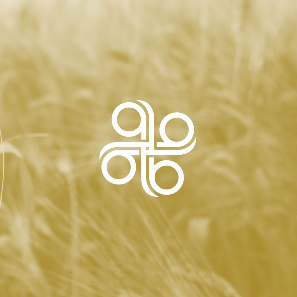 A white geometric symbol with loops and circles is centered on a yellow-tinted blurred background of tall grass, evoking smart branding that’s disrupting the traditional look of life insurance.
