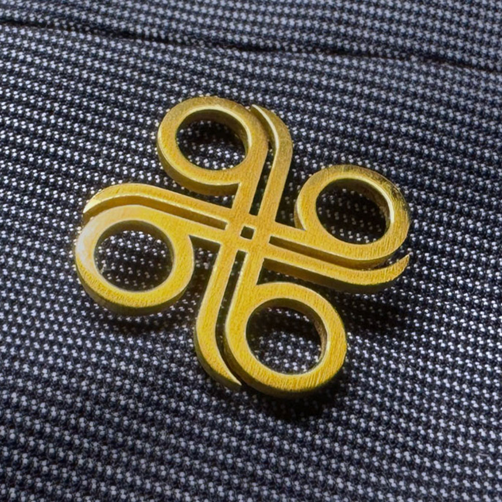A yellow command key symbol pin, ideal for smart branding, rests on gray and white checkered fabric.