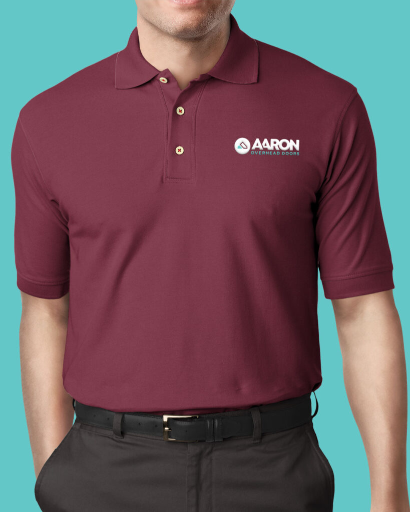 Man wearing a maroon polo shirt with the Aaron Overhead Doors logo, standing against a turquoise background.
